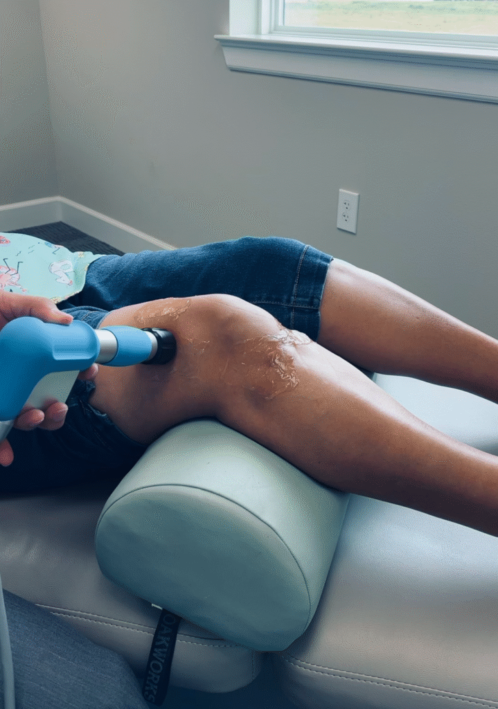 Patient receiving extracorporeal shockwave therapy on shoulder at Flex Chiropractic in Pearland TX